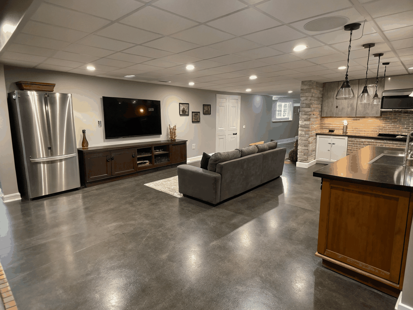 Finished luxury basement renovation with modern recessed lighting, wet bar, and custom built-in cabinetry in Brookhaven