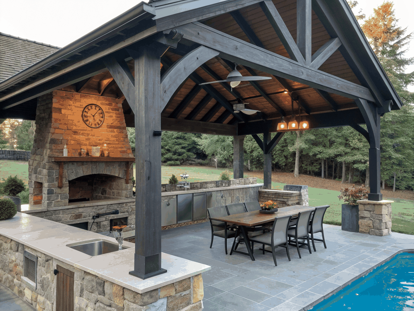Vaulted timber screened porch with stone fireplace and outdoor seating