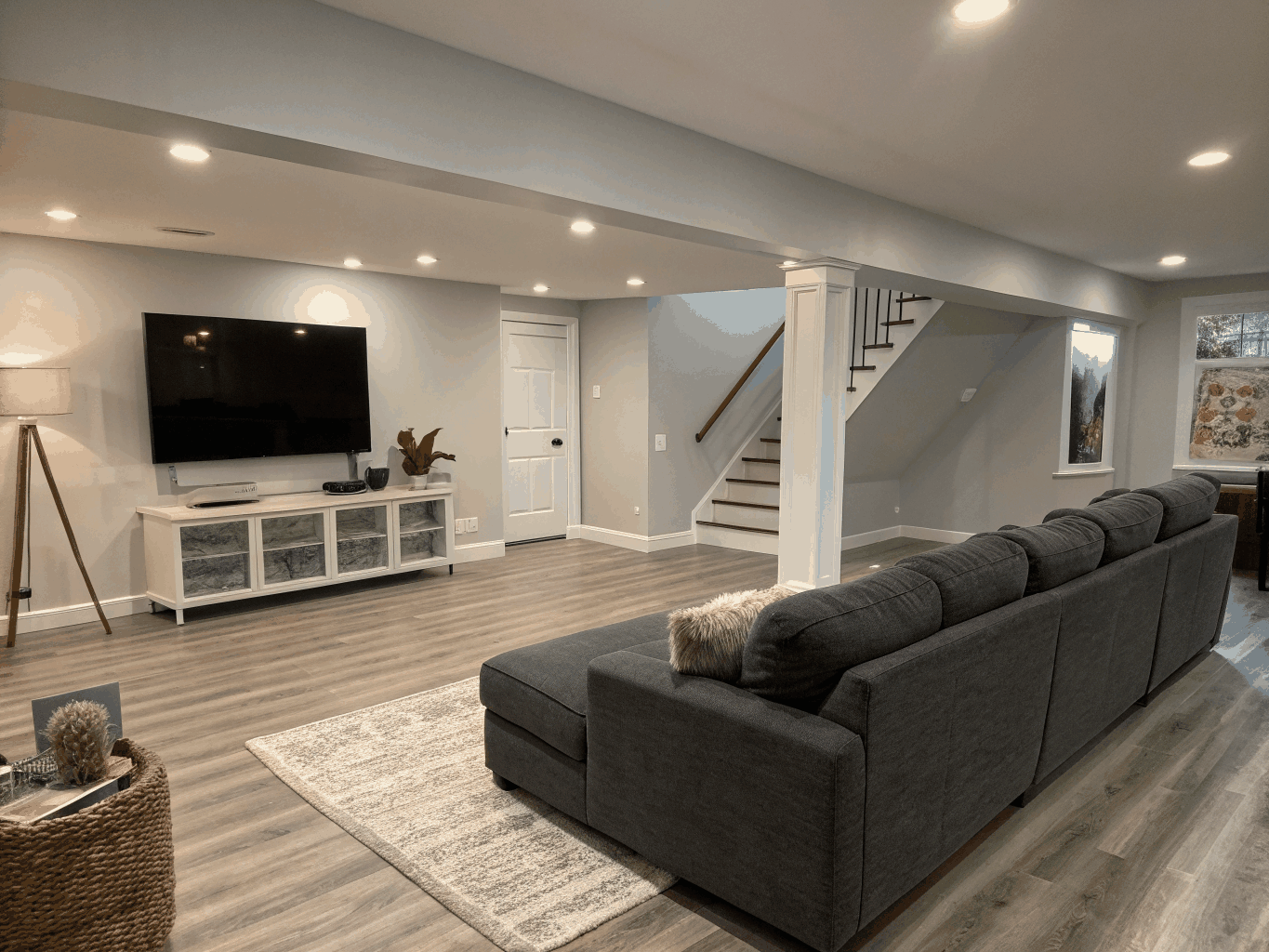 Finished basement living room with recessed lighting and egress window