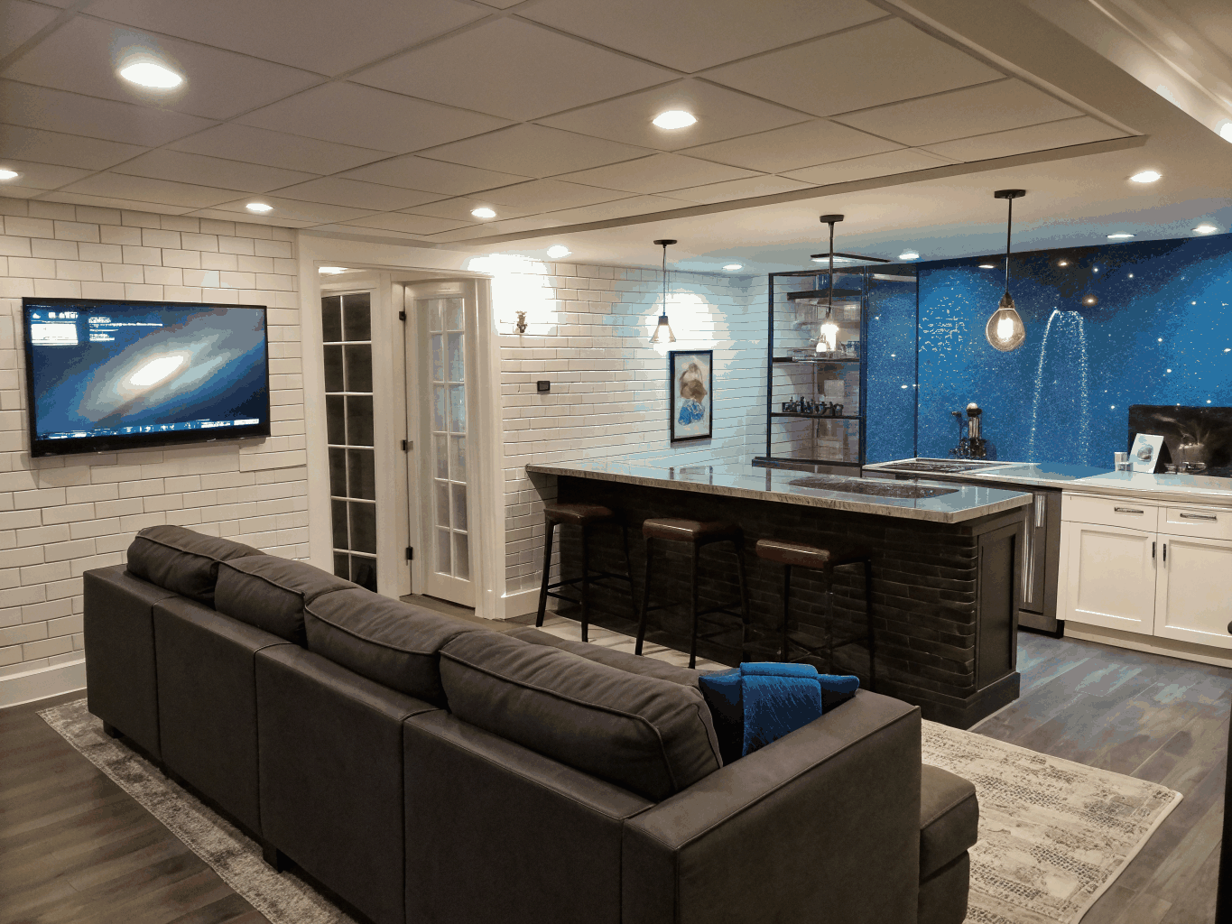Custom finished basement in Brookhaven with built-in wet bar, recessed lighting, and modern entertainment area