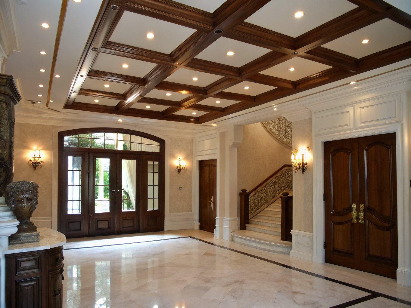 Two-story grand entry foyer with custom wall paneling and architectural iron staircase