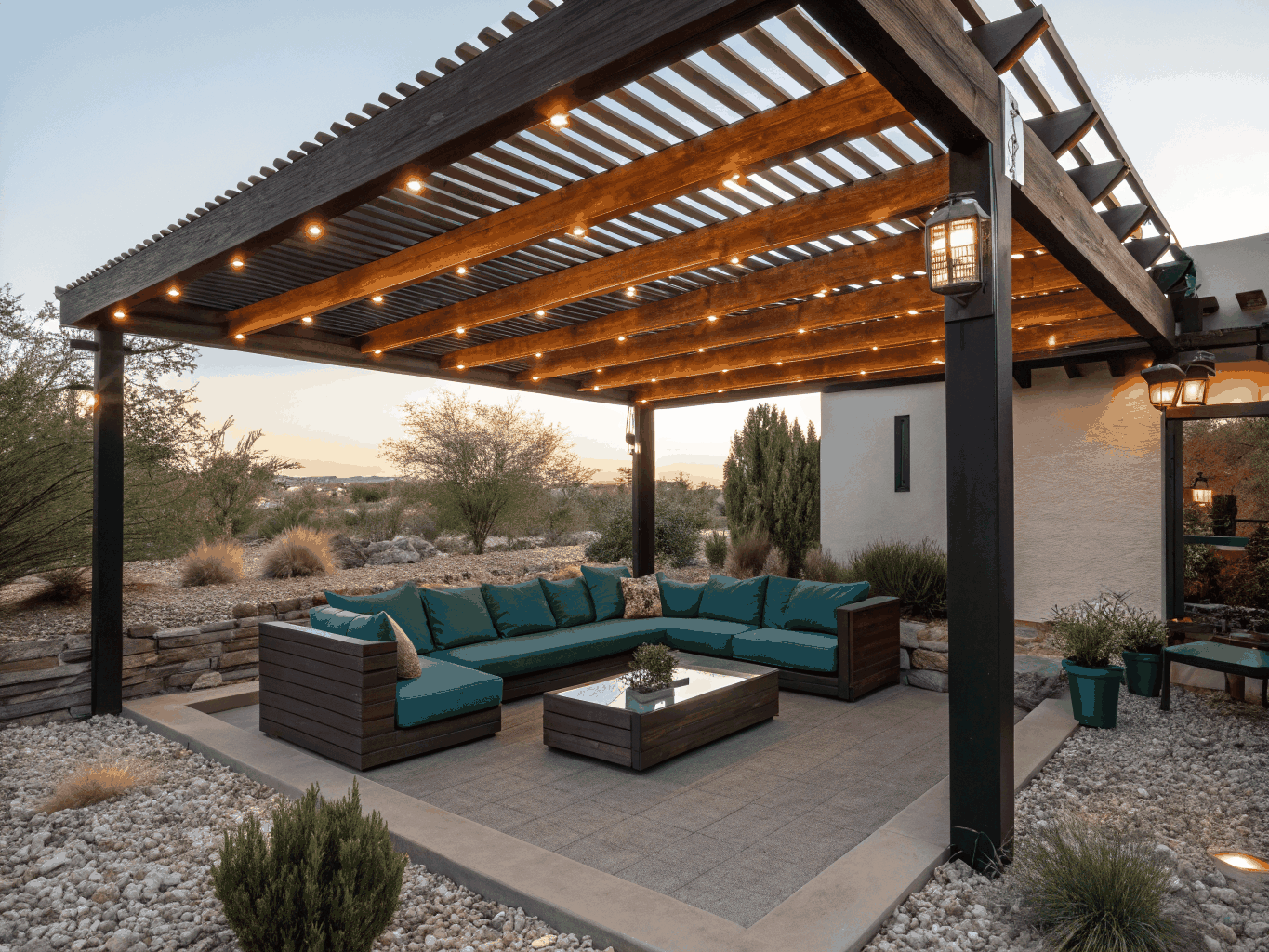 Covered outdoor patio with cedar beams, stone pavers, and exterior lighting