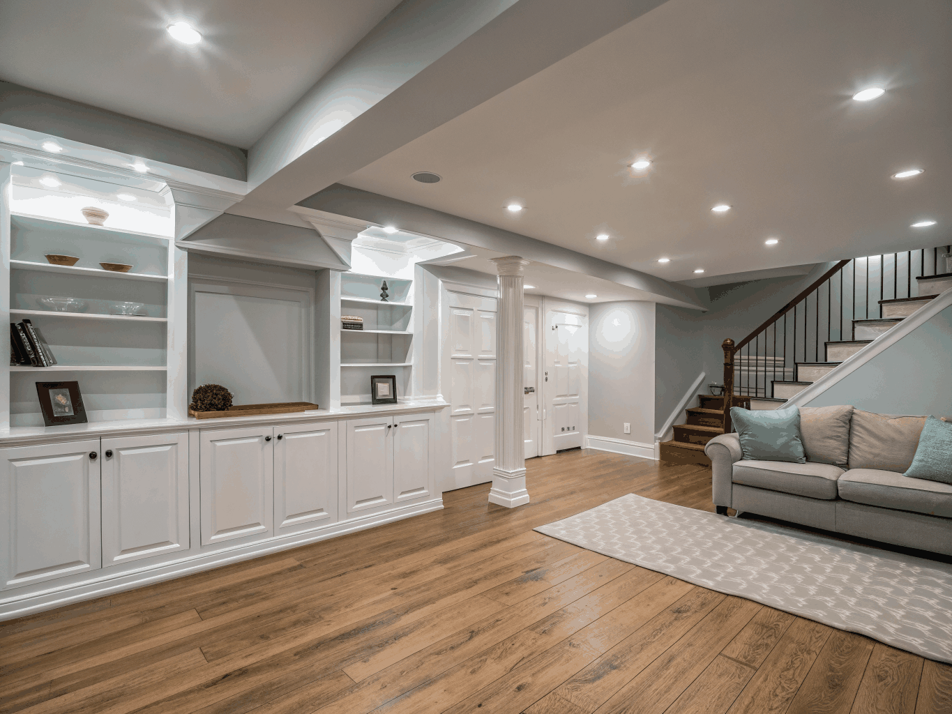Custom finished basement remodeling with recessed lighting, luxury vinyl plank flooring, and custom cabinetry