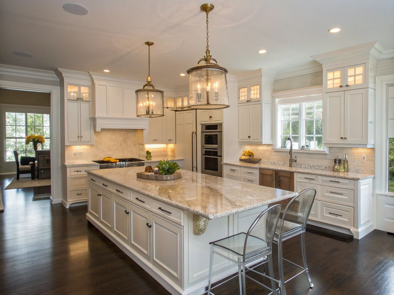 Completed bright transitional kitchen with marble island, brass pendant lights, and polished hardware